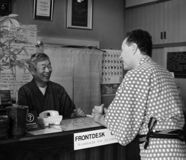 写真／フロントで会話するご主人と浴衣姿の外国人宿泊客
