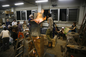 写真：ふいごを踏む日本人の大学生たち