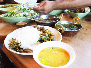 写真：テーブルに並んだダルカレーやサラダ